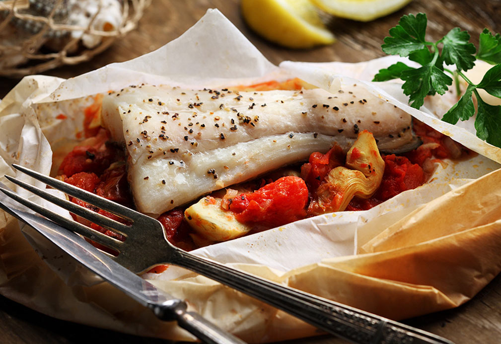 Flétan en papillote avec ragoût aux tomates et artichauts